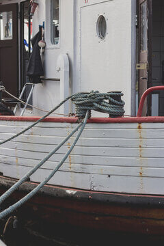 Coiled Mooring Rope On Fishing Boat Deck With White Hull And Red Trim