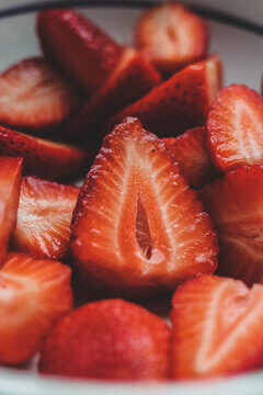 Fresh Sliced Strawberries In White Bowl Showing Juicy Red Texture And Seeds