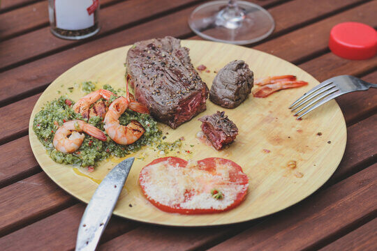 Grilled Surf And Turf Meal With Steak Shrimp And Chimichurri On Bamboo Plate