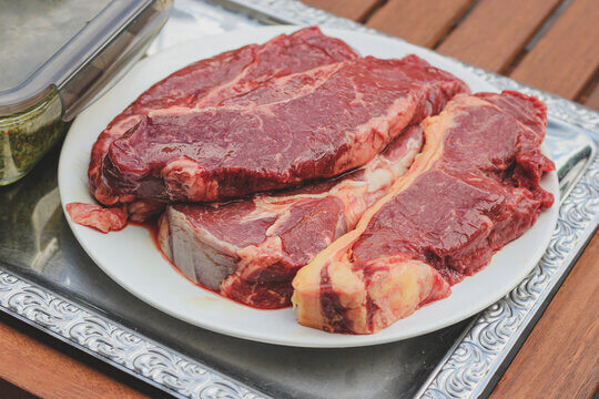 Premium Raw Ribeye Steaks With Beautiful Marbling On White Plate Ready For Bbq